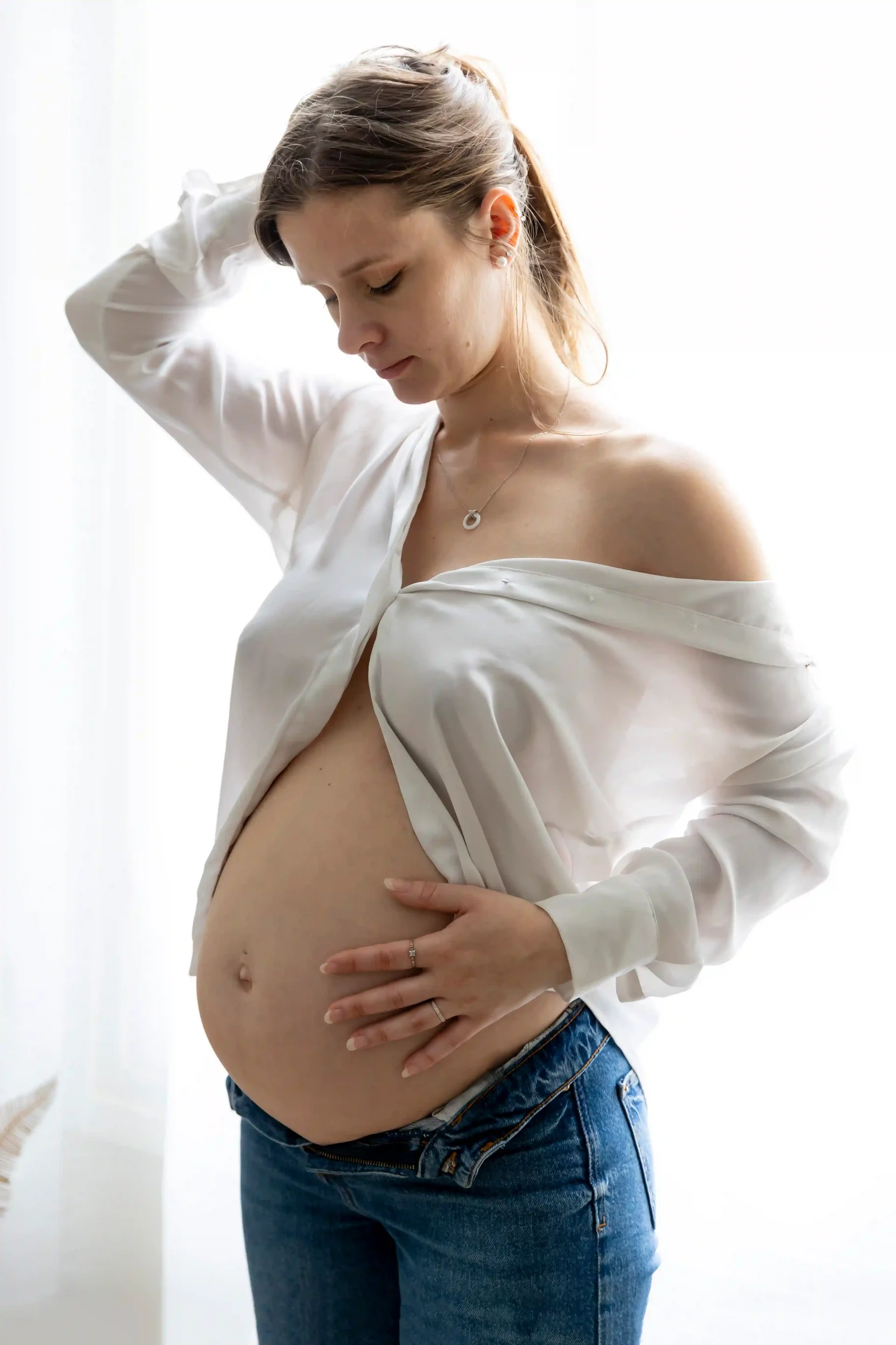 photo de grossesse, maman en jean et chemise blanche