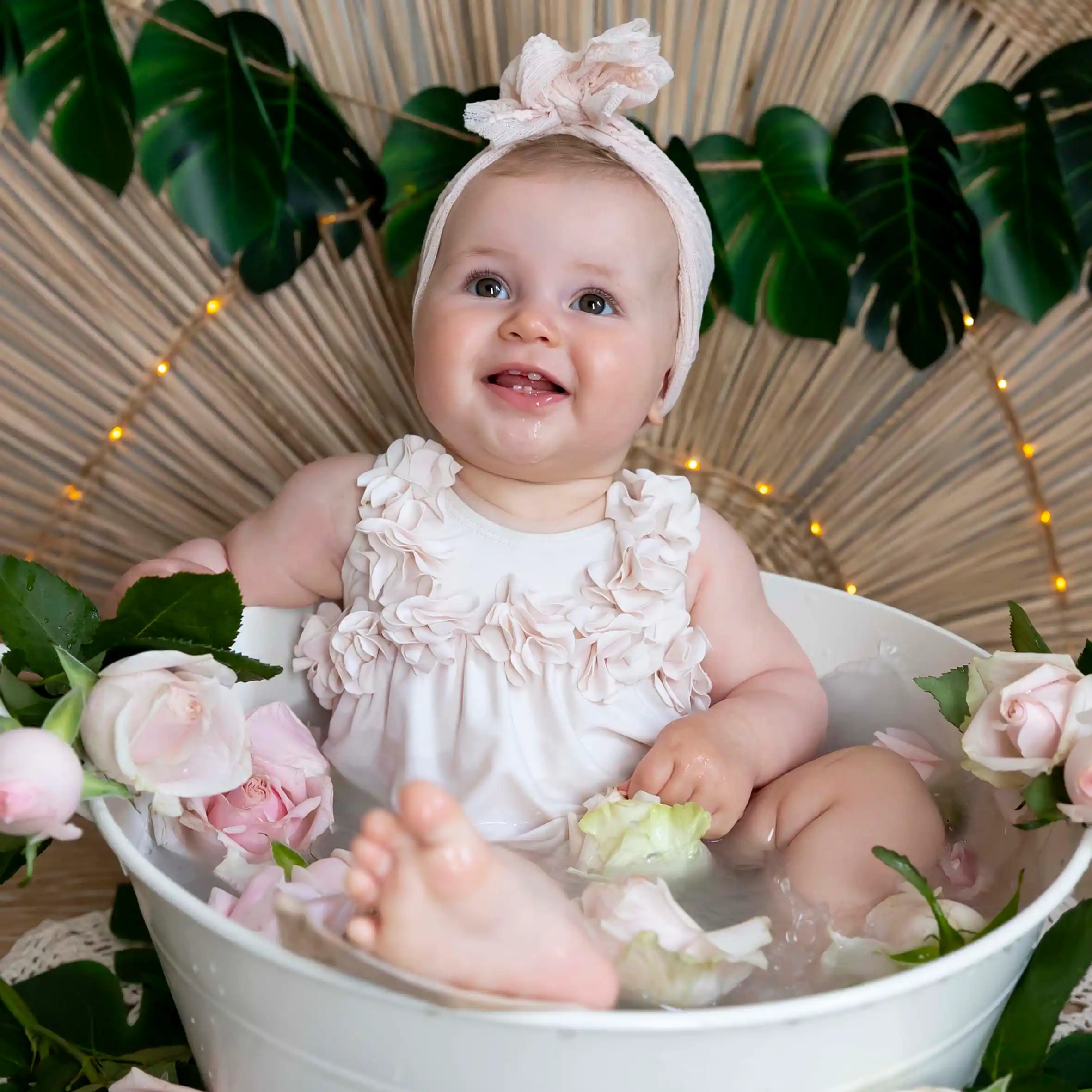 photo bain de lait, bébé entourée de fleurs roses