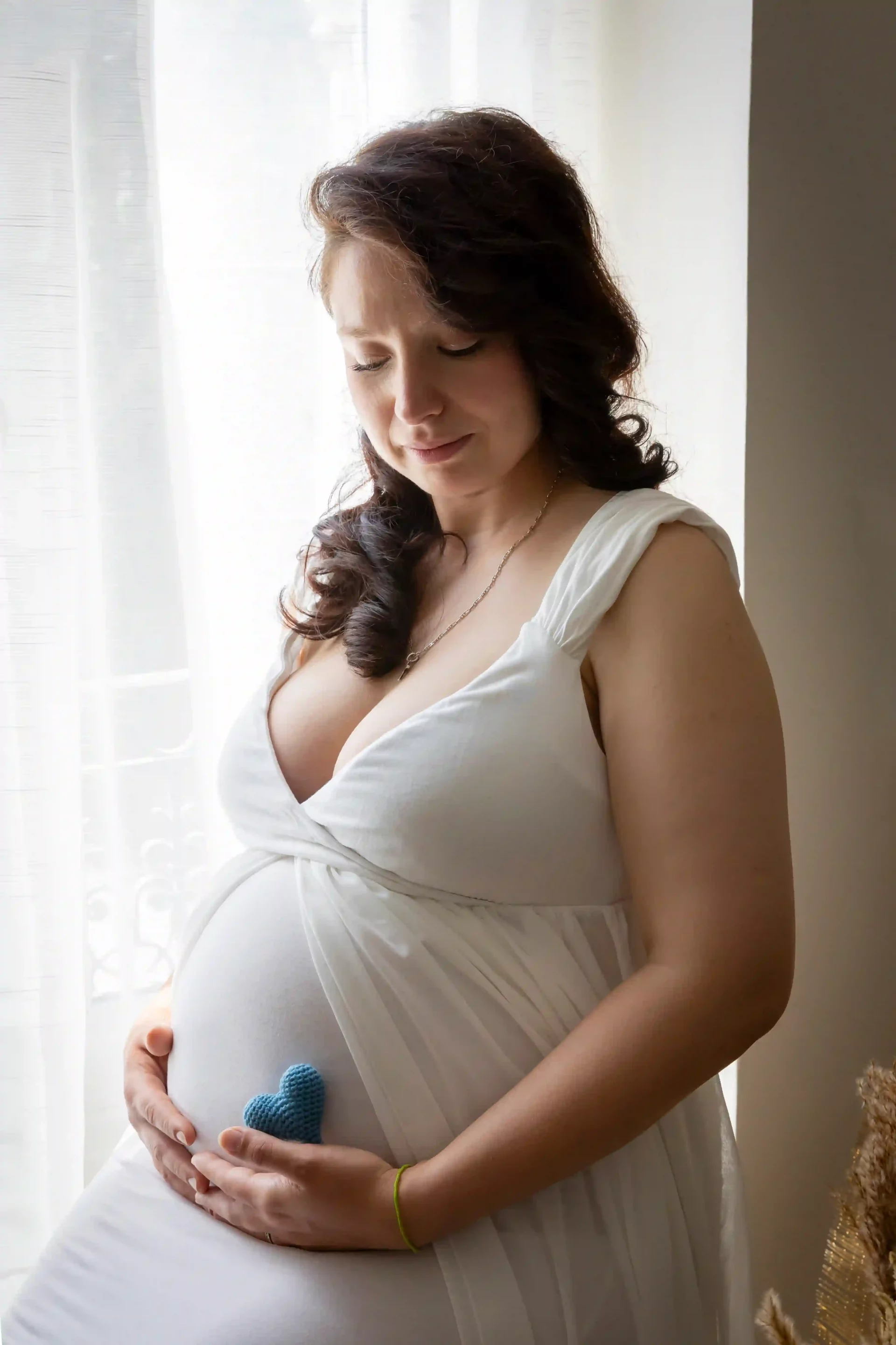 photo grossesse, future maman tenant un cœur bleu sur son ventre