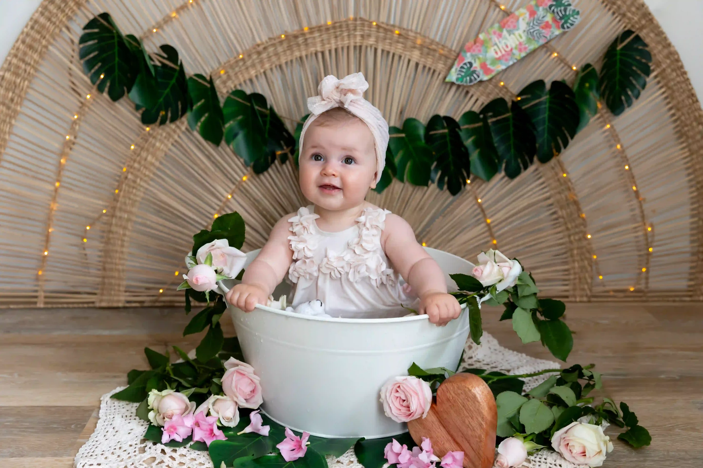 photo de bain de lait, petite fille entourée de fleur roses, dans un décor tahitien
