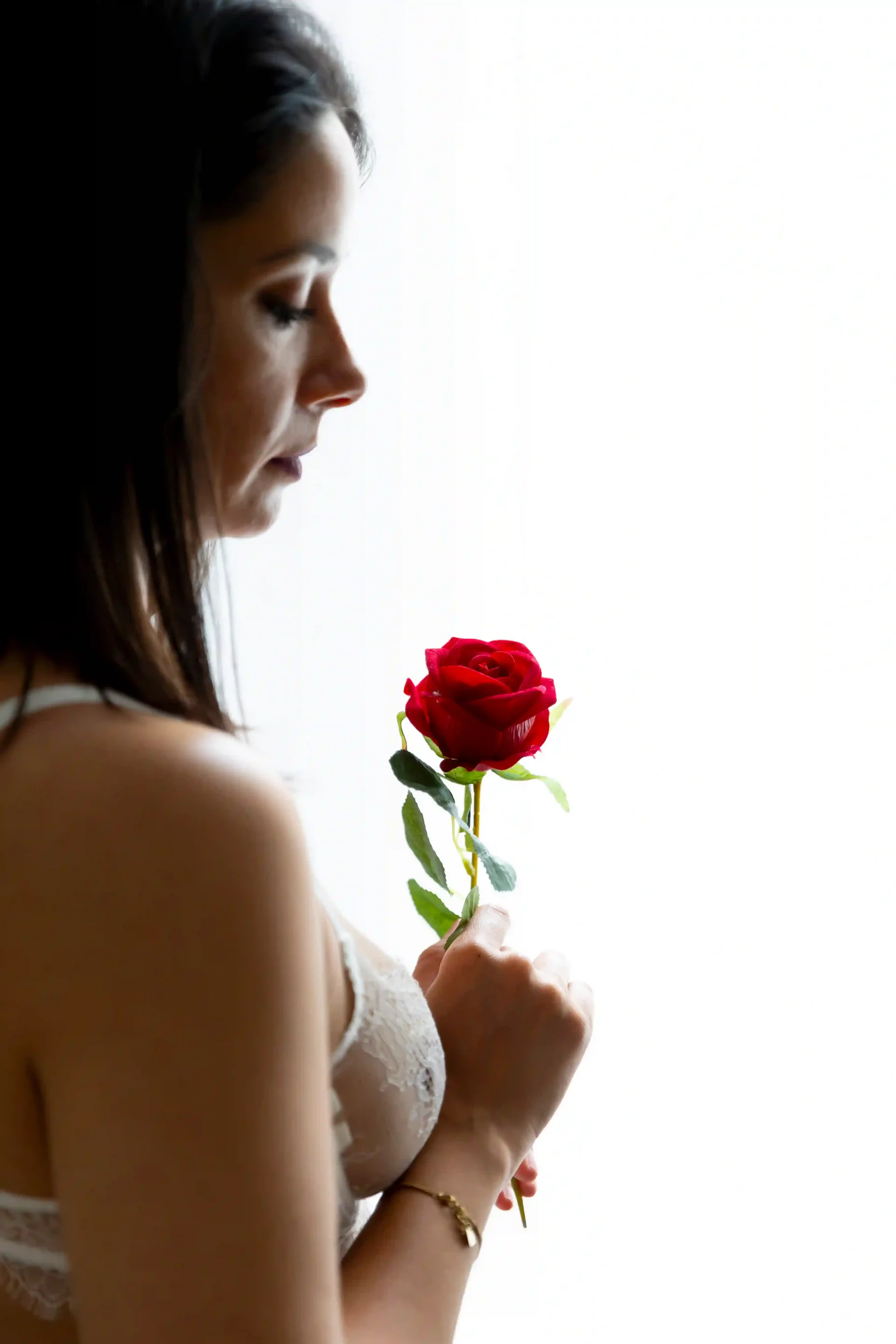 photo boudoir, femme tenant une rose rouge devant elle