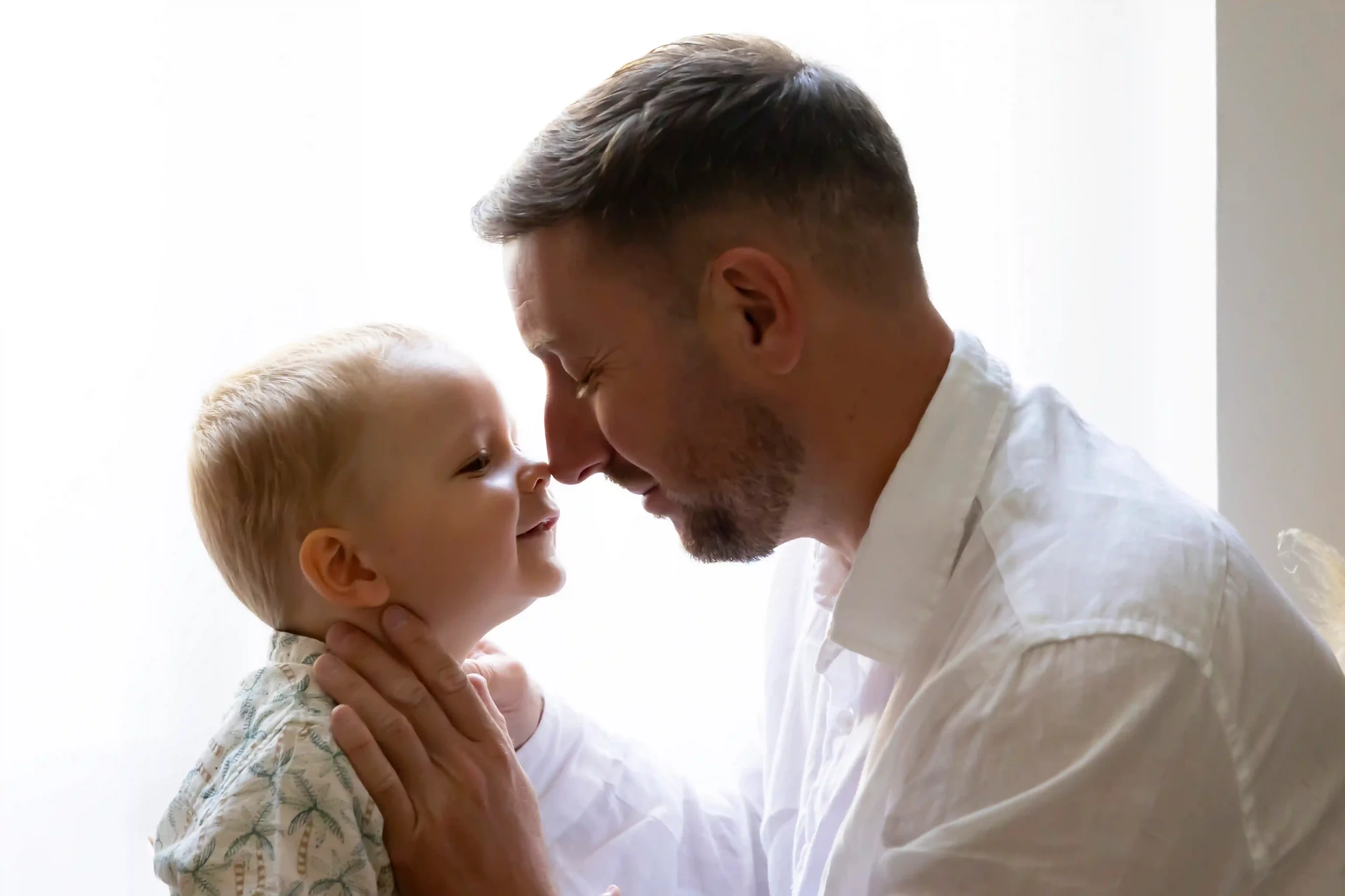 photo de famille, papa faisant un bisou esquimau à son fils
