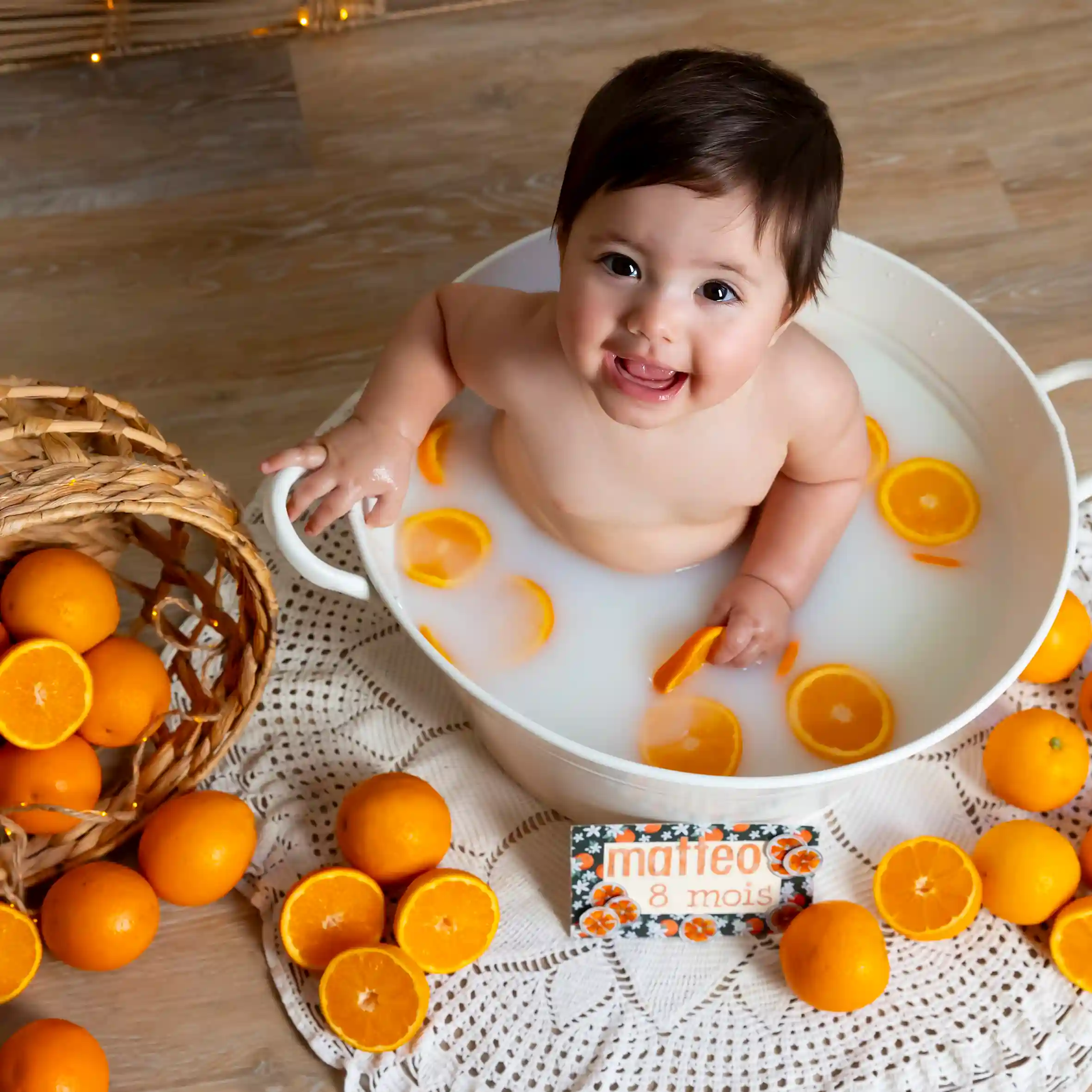 photo bain de lait, bébé entouré d'oranges