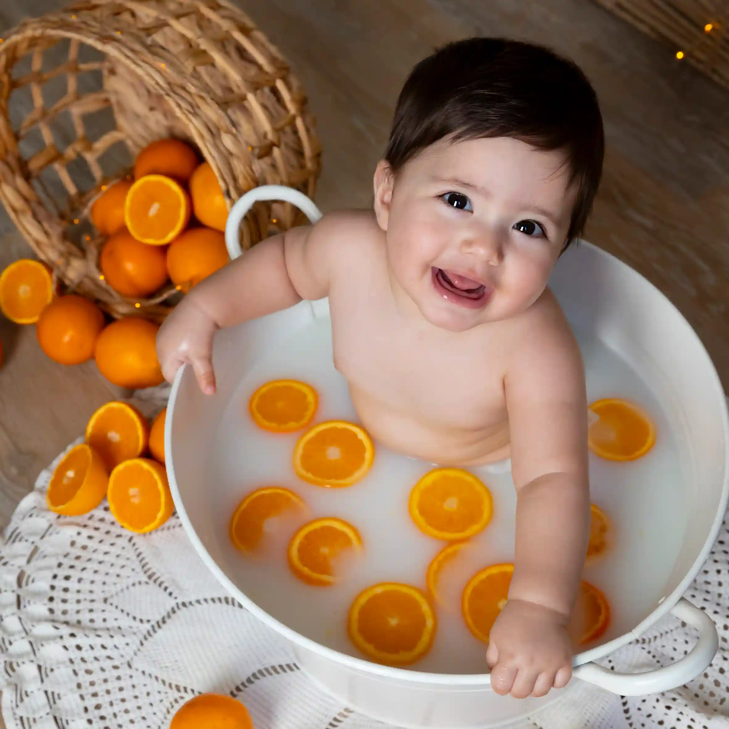 photo bain de lait, bébé entouré d'oranges
