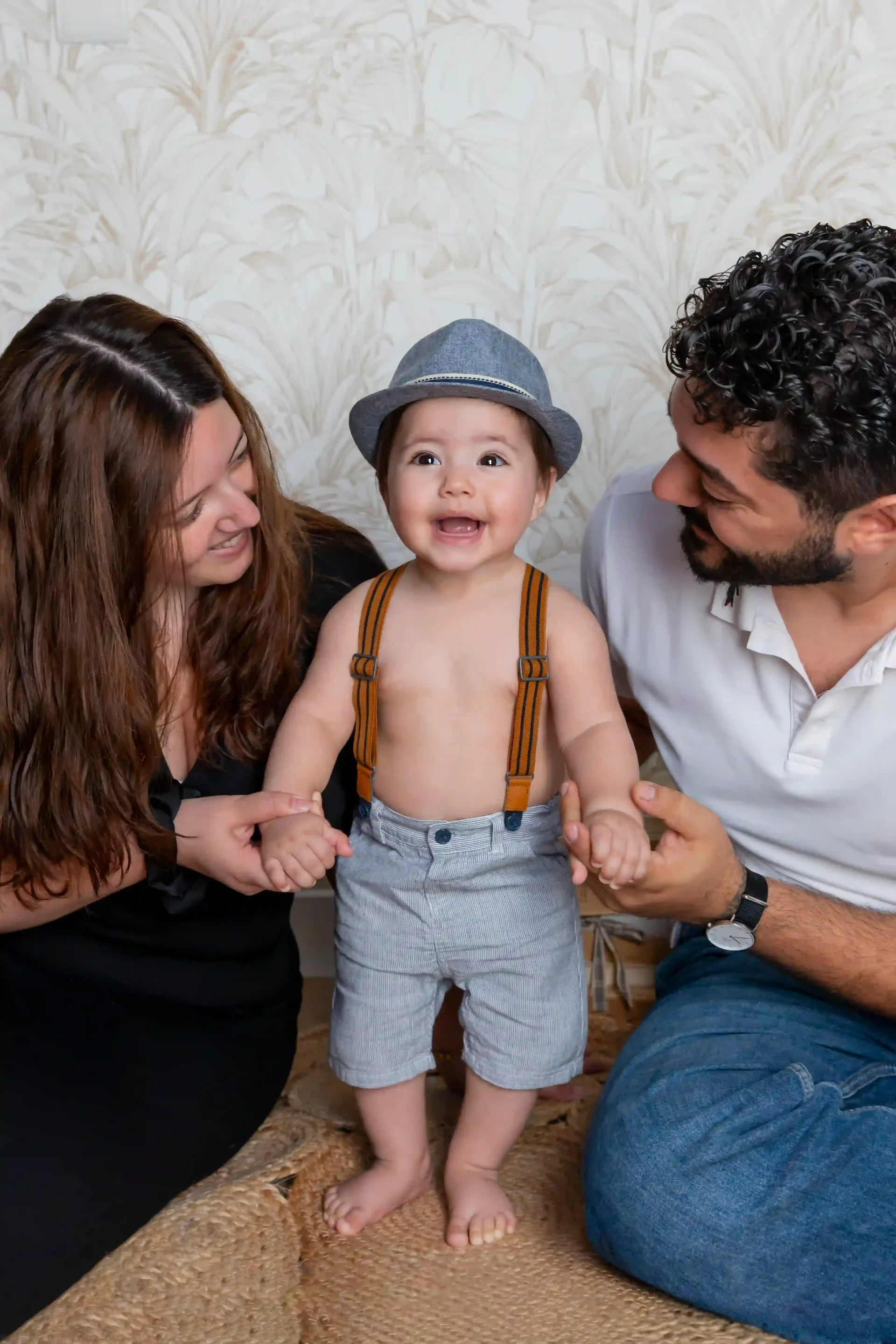 photo de famille, bébé de 9 mois debout entre ses parents