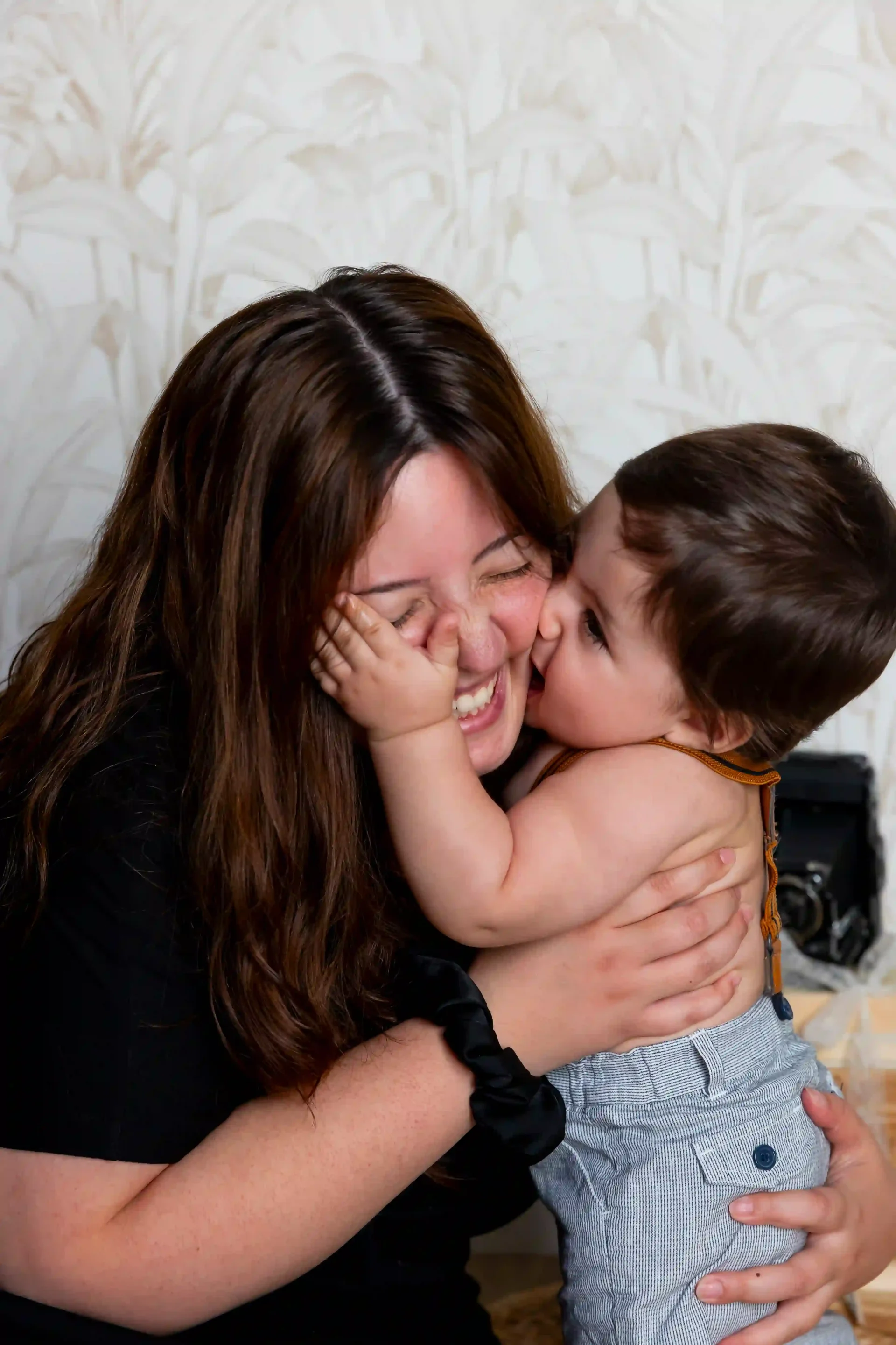 photo de bébé, qui mange la joue de sa maman